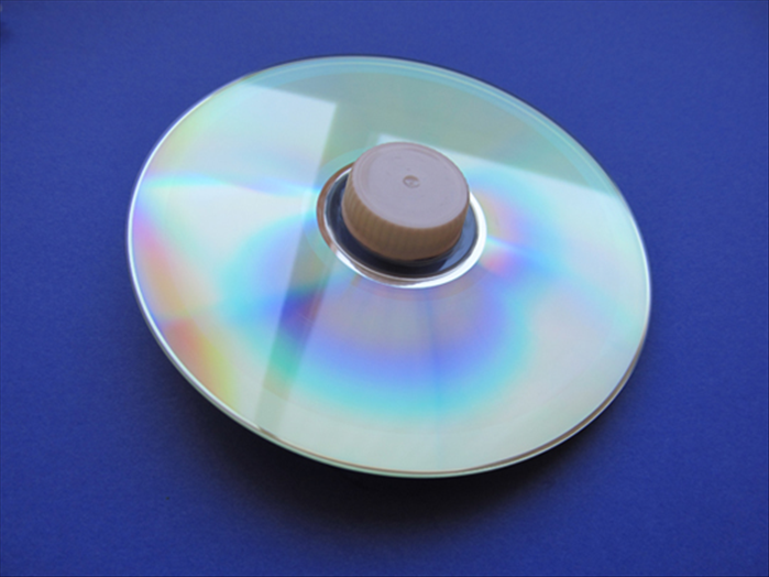 To make a a spinning top from a cd you will need:
An old cd
A plastic bottle cap
1 marble
Glue that adheres plastic and glass together
