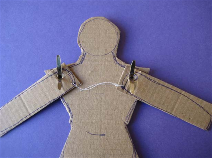 Put paper fasteners through the torso and then the arms.

knot a string loosely at each dot.
