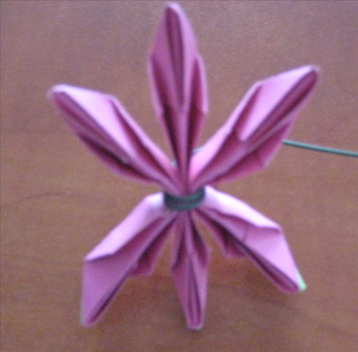 Squeeze the top and bottom  papers in half to create a star shape