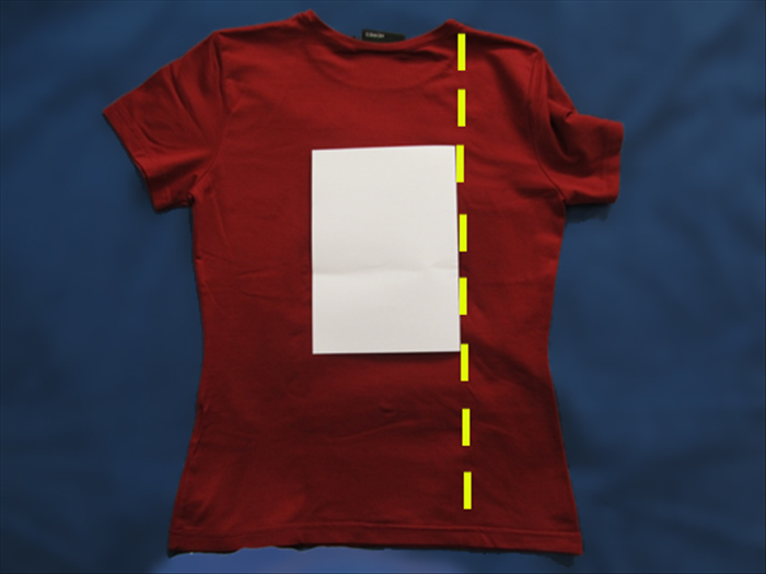 Spread your shirt on a flat surface
Rotate the paper so that the folded edge is on the side.
Place the paper in the center of the shirt.
Bring one side of the shirt over the paper
