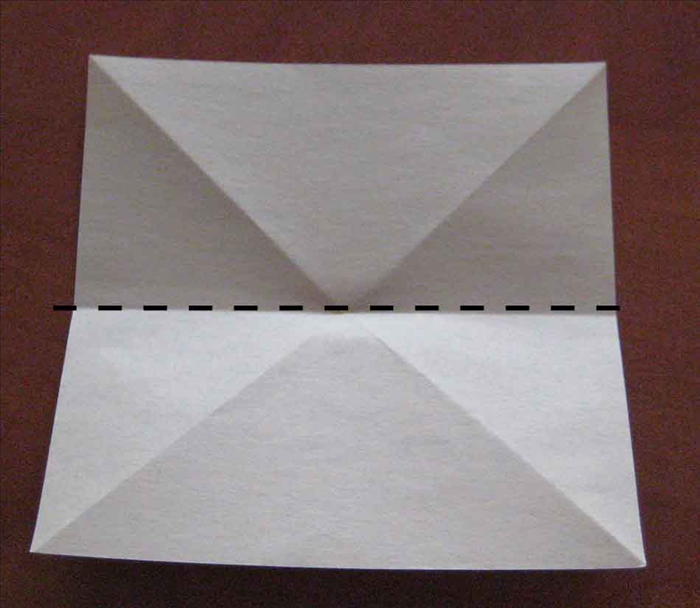 Flip the paper over to the back side.

Place the paper  so that the straight edges are on top, bottom and sides.
Fold in half horizontally and unfold.