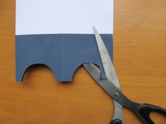 <p> A little piece of the small folded area will be sticking out of the arc. Cut it off along the arc edge.</p>