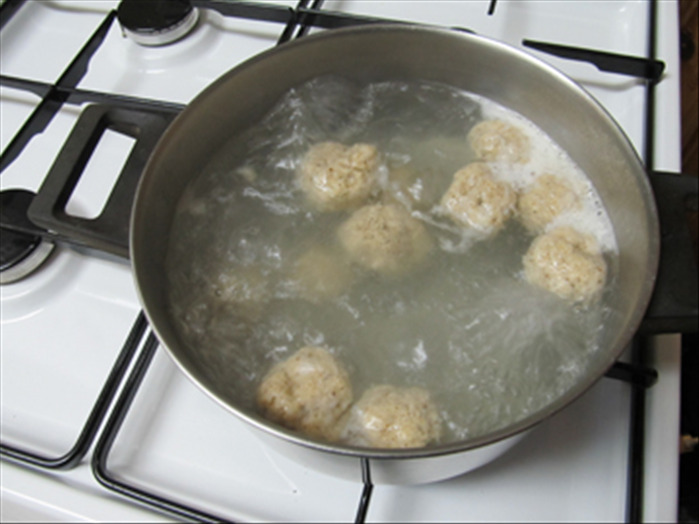 Bring a pot of water to boil
Wet your  hands with water, make balls from about 1 tablespoon of the mixture  and drop them into the boiling water
Cover the pot and cook the matzo balls  30 -40 minutes
