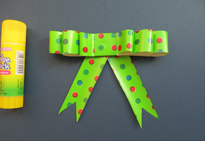 Glue them at an angle to the bottom of the bow.
 
Your bow is ready to decorate your gift!
