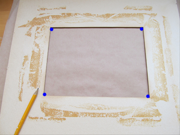 Place the paper or material face down.
Place the mat face down centered on top of it.
Make a dot on the paper or material at each corner of the window of the mat.
