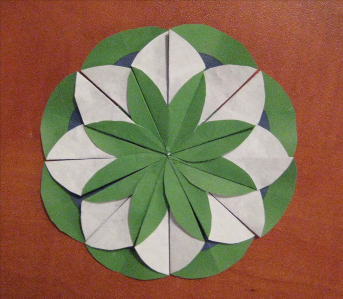Glue the remaining 4 folded circles in each empty space. 
Lift each right flap so that it overlaps the one next to it and your medallion is finished.