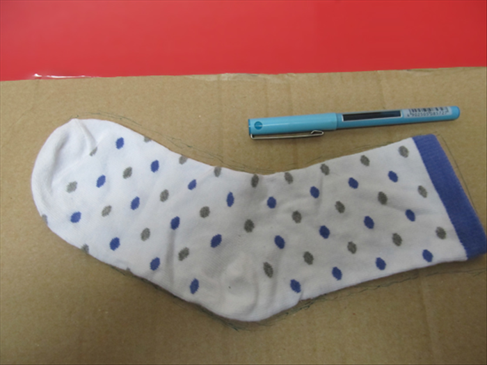 <p> Trace the outline of the sock on cardboard or stiff paper.</p> 
<p> Cut out the shape.</p> 
<p>  </p>