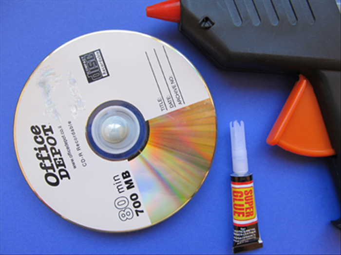 When the glue has dried completely turn the cd over to the other side.

Glue the marble in the hole of the cd. 
It will go in only about ¼ of the way.
