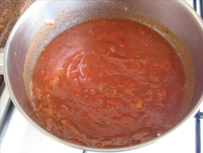 Fry the onion until translucent in a sauce pan.
 Add the garlic and fry another minute

Add the tomato paste, salt, pepper, oregano, basil , sugar and water
Bring to a boil.  Cook for a few minutes on low heat.

 Turn off heat
.

