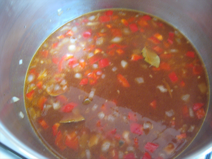 Add the tomato paste, water, bay leaf, turmeric, salt, pepper and wine
Mix and bring to a boil

