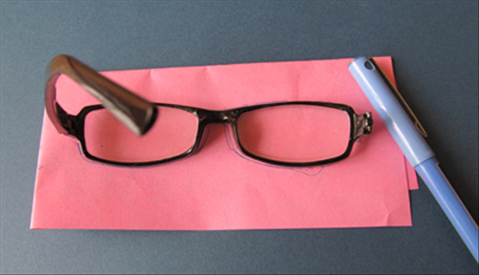 <p> Trace the outline of a pair of glasses on scrap paper.</p>