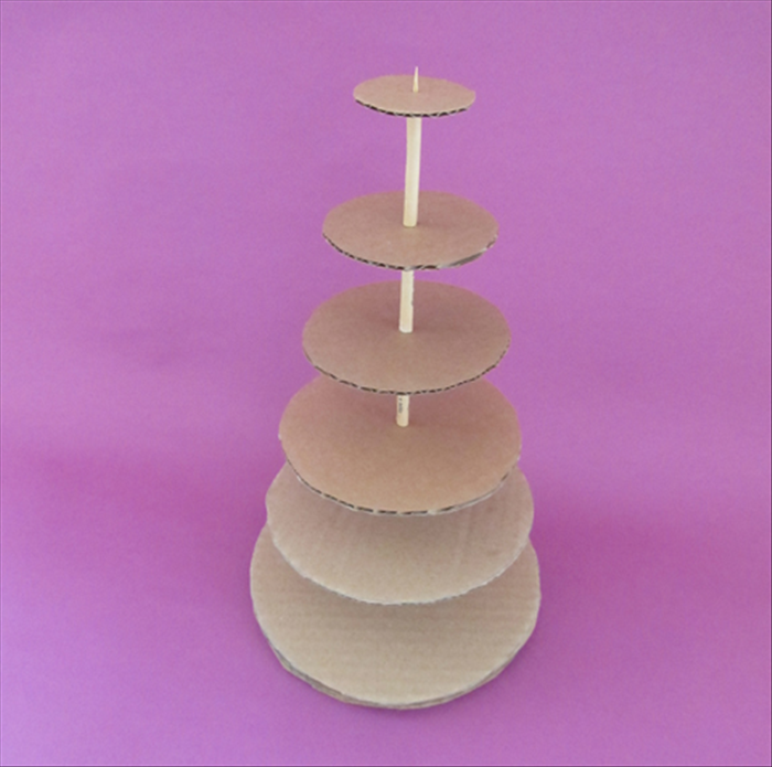 <p> Slide the next largest cardboard circle down the skewer and then a rolled paper with glue on top.</p> 
<p> Repeat until you have glued all the circles.</p> 
<p> When the glue has dried your cardboard tree will be ready to decorate.</p> 
<p> You can stick a star on the point at the top.</p> 
<p> Have fun decorating!</p>