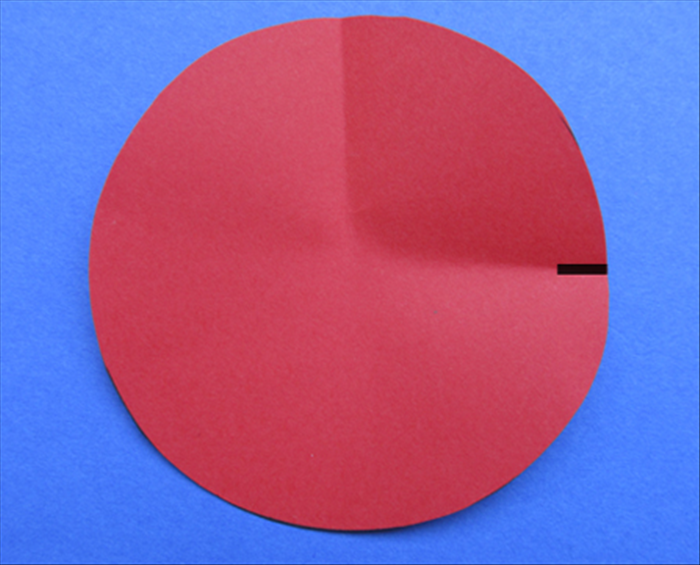 Rotate the circle and bring the top and bottom together as if you were going to fold it in half. Do not crease it, just make a pinch to mark the quart way.