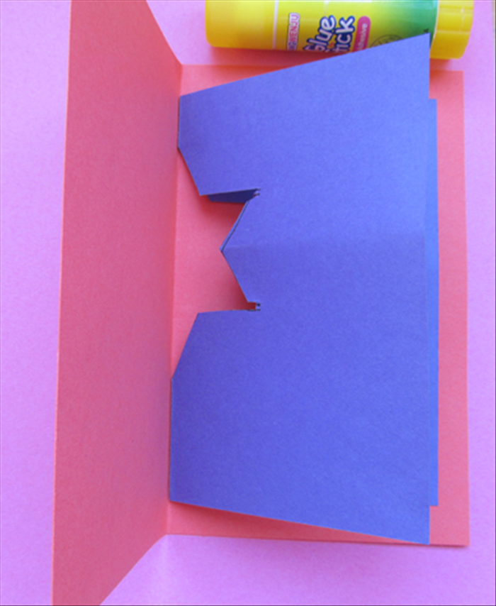 <p> Fold the larger paper in half, align the creases and glue both sides in place.</p>
