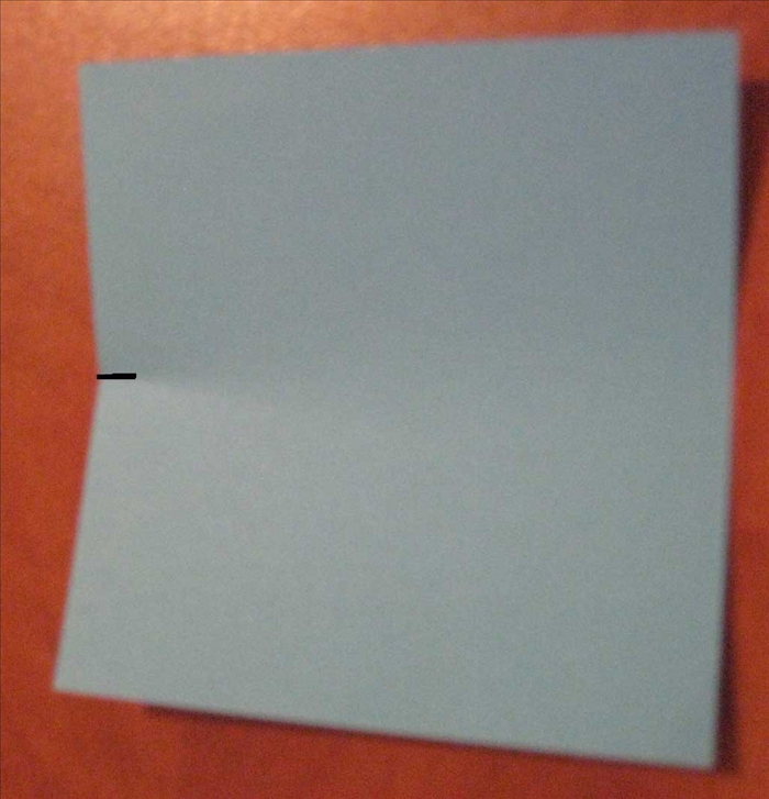 Bring the top edge of the square paper down to the bottom edge. Do not fold it, only pinch to make a half way mark