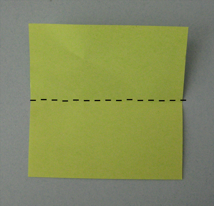 Bring the top edge down to fold the square scrap paper in half