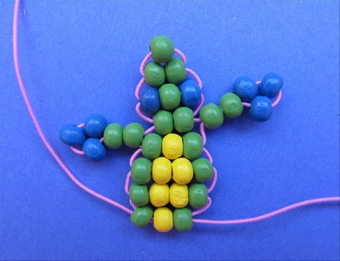 Repeat the process of inserting the second string through the beads by way of the opposite end.
The next two rows use 1 green 2 yellows and one green.
The row after that uses 1 green 1 yellow and 1 green.
