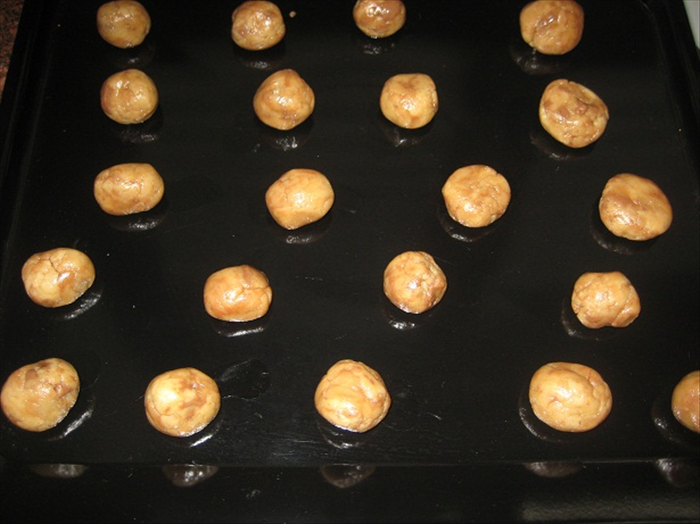 Make balls from a heaping tablespoon of dough and put them on a baking sheet.
You can flatten the balls with the bottom of a cup or leave then round.

Bake for about 8 minutes  or until they are a light golden brown 

