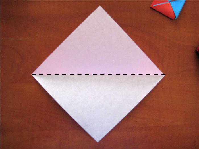 If using paper of 2 colors place the colored   side you want for the outside petal facing down

Place the paper with the points on the top, bottom and sides.
Fold the paper in half horizontally. unfold.
