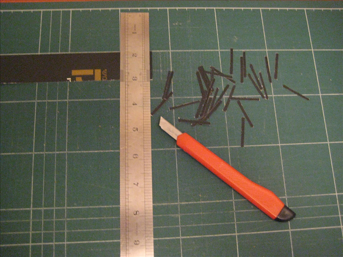 To make the dividers on the dominos cut 28 strips of a dark colored paper 1/8 of an inch  X  1 1/4 inches.

The 1 1/4 inches is the width of the cardboard 
rectangles.