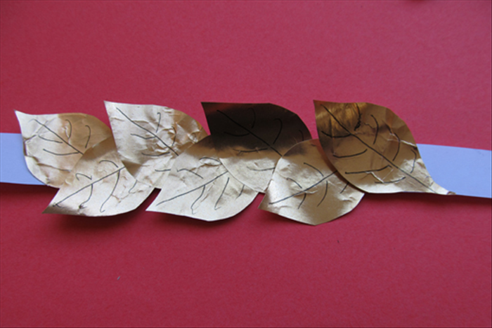 Continue gluing leaves alternately pointing up and down until you have covered most of the strip
