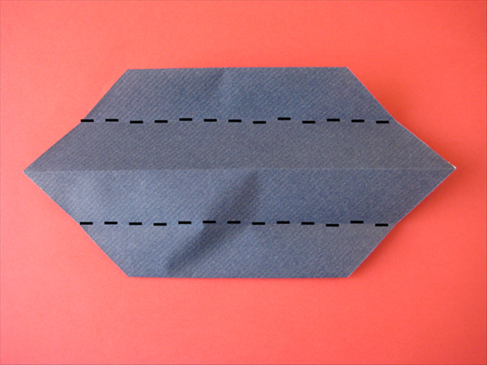 Flip the paper over to the back side.

Bring the top and bottom edges to align with the center crease.
 A triangle of paper will pop up from underneath. See the next picture for result.