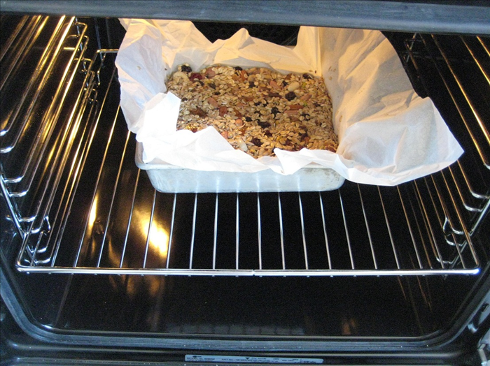 Oil a baking pan and put a layer of parchment paper in it. Pour the mixture into baking pan.
 Use a piece of the parchment paper to  press down the mixture evenly into the pan.  

Bake for 25 to 30 minutes, until light golden brown. 
 *Check to make sure it does not burn
