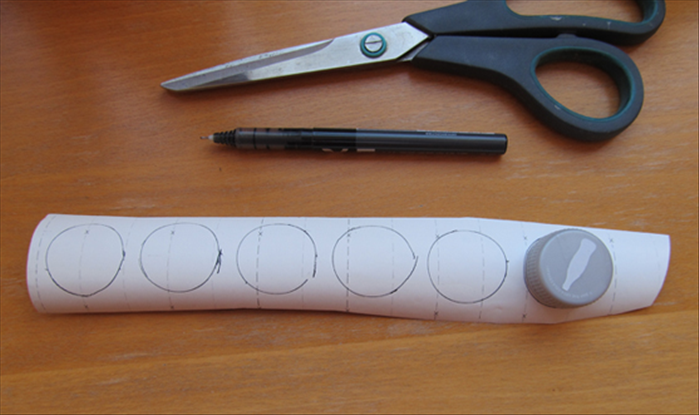Trace the outline of the bottle cap 6 times on gold or colored paper. 
Cut out the circles.