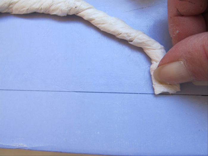 Cut the other end of the tissue paper rope and align it to the drawn line.
