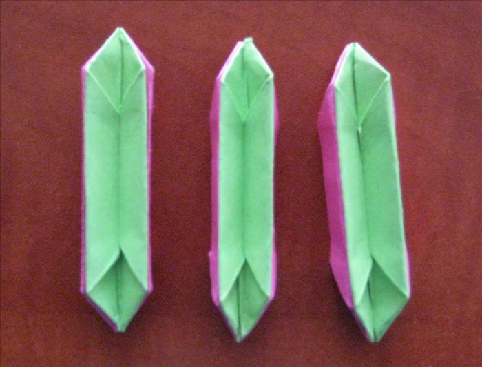 Place the 3 green papers inside of the 3 pink ones