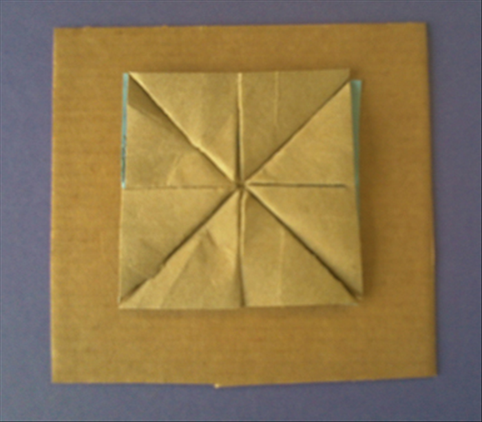 Glue 4 brown triangles on the center of the square cardboard