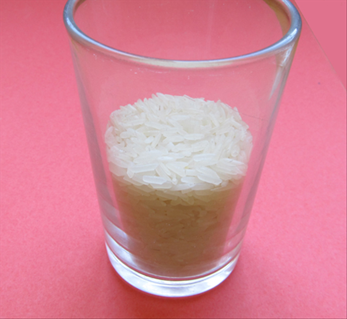 Pour ½ cup of rice or other small grains into a glass