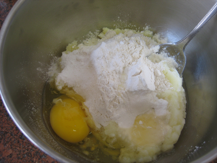 Put the 1 cup of mashed potatoes in a bowl  and add the flour, baking powder, salt  and egg
Mix them together well
