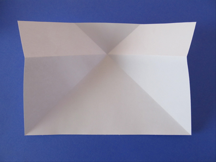 Flip the paper over again.
Stick your fingers under the horizontal fold and lift and push the sides towards the center.
