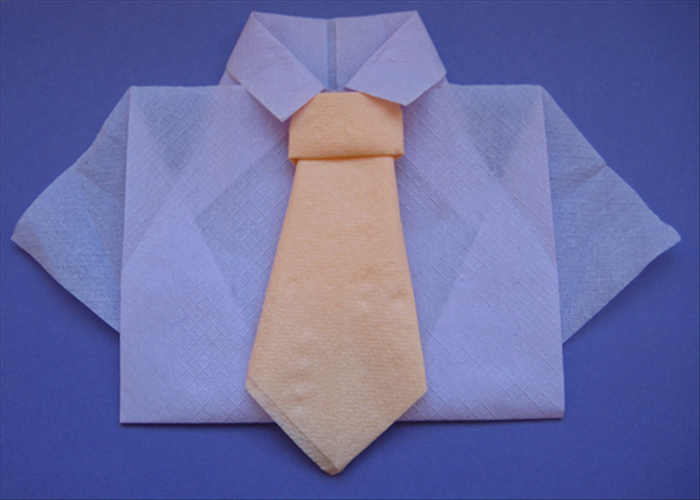 Flip the napkin back over to see the finished tie.

You can place it on a plate as is or add it to a napkin folded into a shirt.