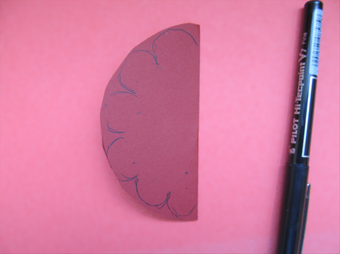 Fold the circle in half
Draw scallops around the curved edge
