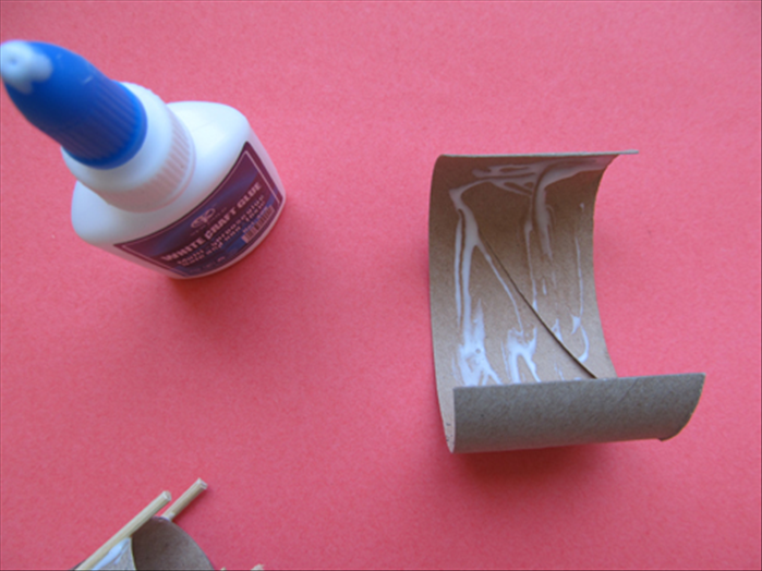 Apply a generous amount of glue inside the curve of the other half of the tube that you cut
