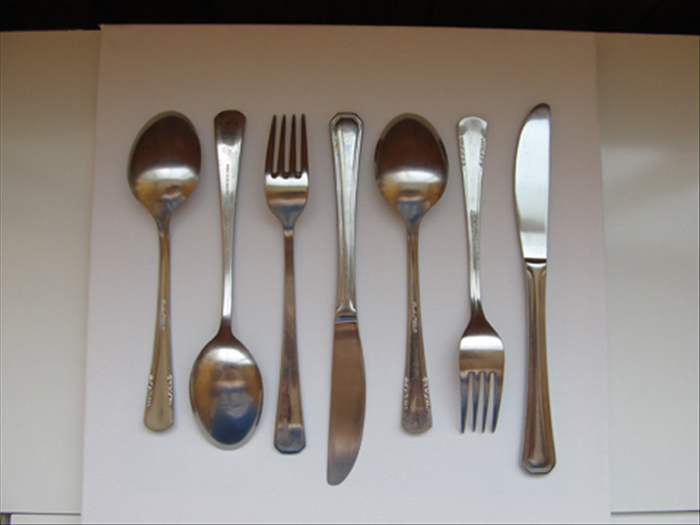 Place your silverware on the canvas in an arrangement that pleases you.
Place the spoons and forks face down.
