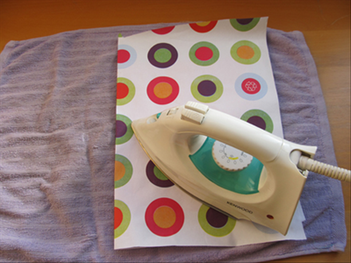 Cover the bag with another paper. 
It is very important that the whole bag is covered with paper to prevent it from touching the iron.

Move a medium-hot iron gently back and forth, a few times, over each area of the bag. 
