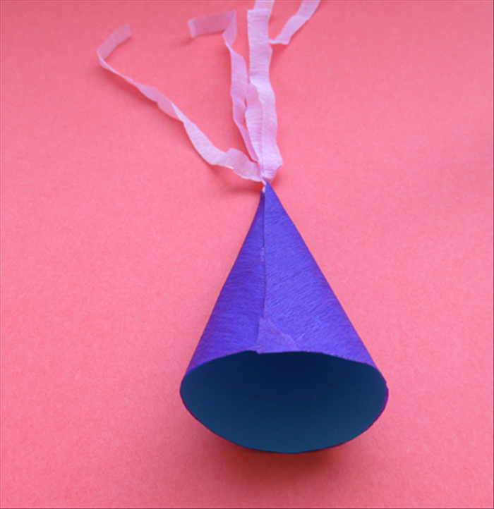 Bring the folded straight edges around and over the other straight edge to make a cone shape. 
Check to see if it fits nicely on you head.

Glue it in place.
