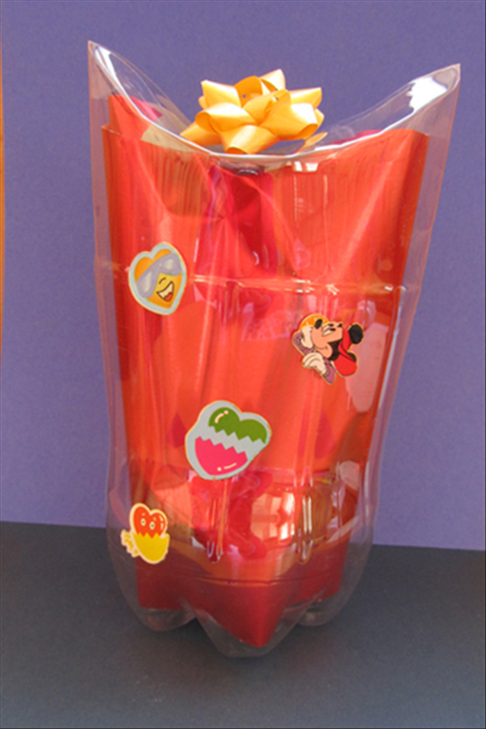 Materials:
Plastic bottle
Small plate
Pen or object with a sharp point
Optional wrapping paper, tissue paper or colored paper
Bows and stickers
