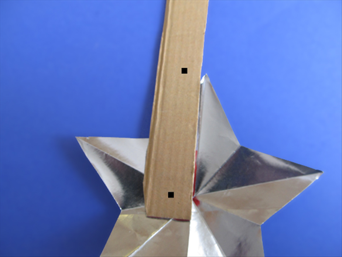 <p> Unfold your star.</p> 
<p> Cut a 12 inch long strip of cardboard.</p> 
<p> Mark the cardboard about 1 / 2 inch from the bottom.</p> 
<p> Align the mark with the center of the star.</p> 
<p> Make another mark at the top point of the star.</p> 
<p>  </p>