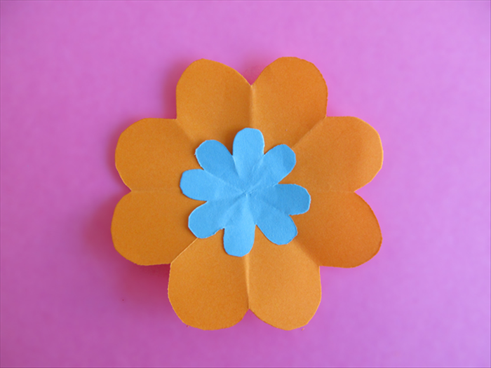<p> Glue a small flower to the center of a larger one</p>