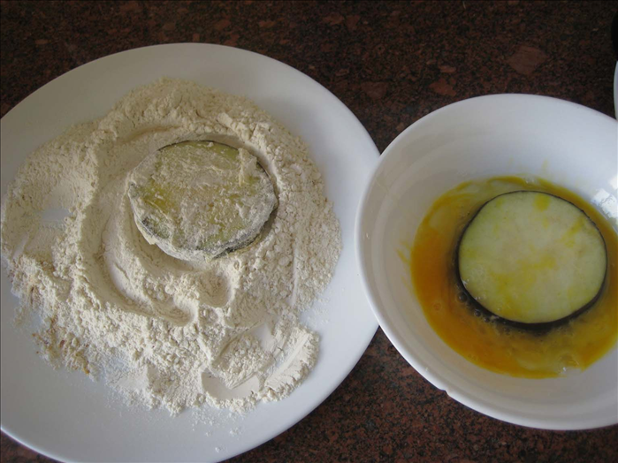 Put 1 egg in a bowl and swill it around 

Mix together 1 cup flour , ¼ cup bread crumbs, a pinch of black pepper and ¼ teaspoon salt on a plate.

Coat the slices of eggplant first in the egg
and then coat them with the flour mixture

