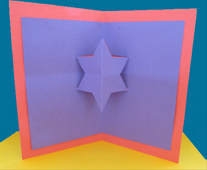 <p> Open to see your ready card. Now you can write your greeting and decorate it.</p> 
<p> If you want to glue a smaller star on top of the cut star, follow  the direction in steps 2 to 6 with a</p> 
<p> smaller square.</p>