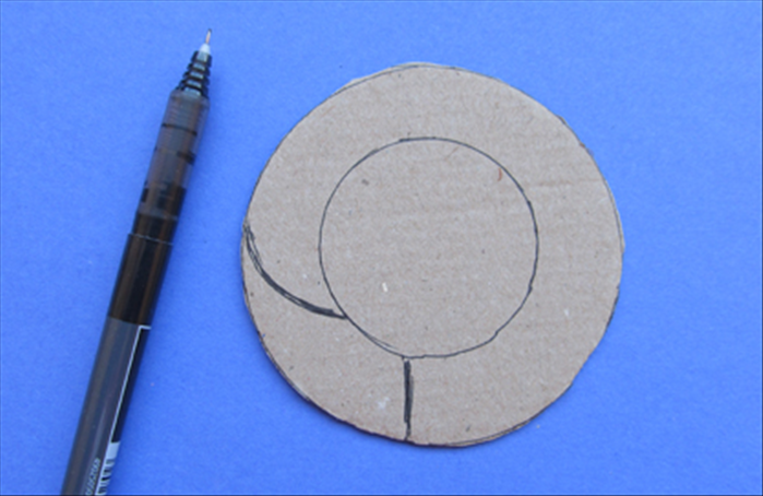 Draw a straight line connecting the 2 circle - a little to the left of the bottom center
Draw a curved line upward as shown in the picture.
Cut between the lines you drew and the lines of the inner circle
