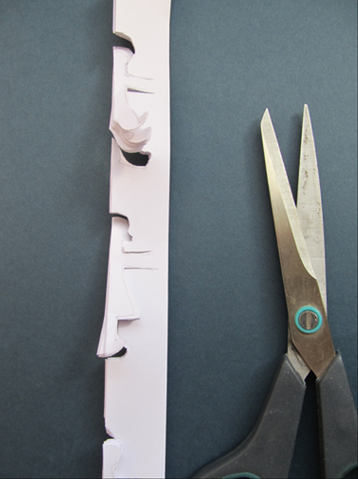 Cut along the lines you made. Make sure to stop cutting a little less than ½ inch from the edge of the arm so that the figures remain attached.
