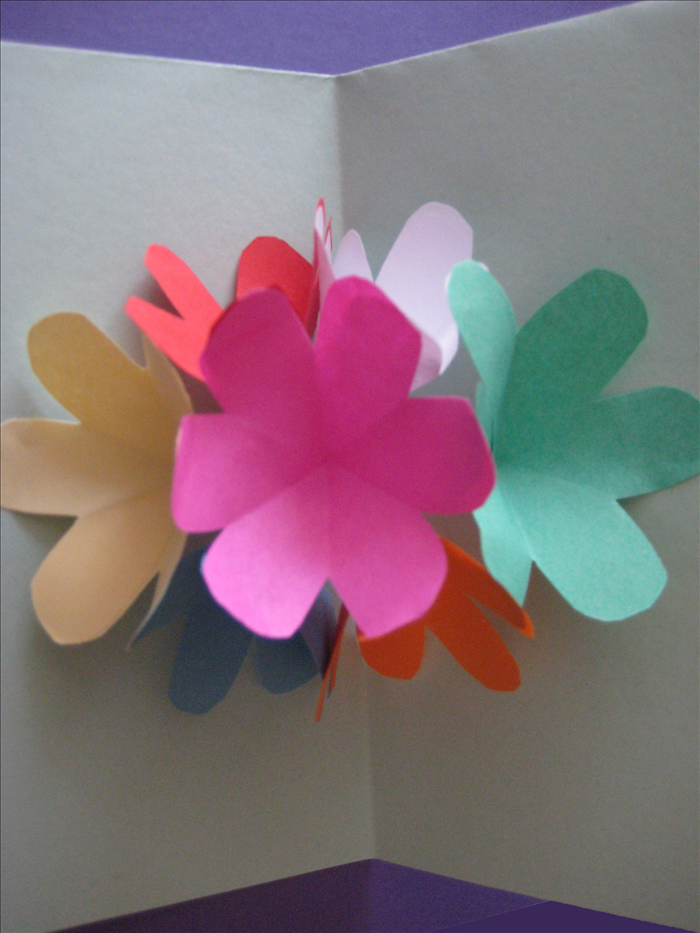 Materials:
7 squares of paper the same size for the flowers
Thick paper for the card base
scissors
paper glue

