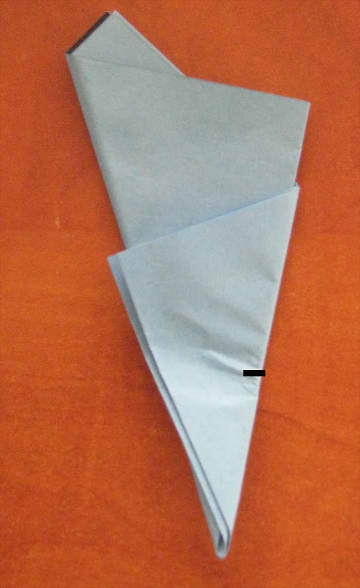 Turn paper so that the narrow point is on the bottom.
  
Take the bottom point and fold it up half way of the right side of the outer  triangle and pinch for  a reference point to start cutting
