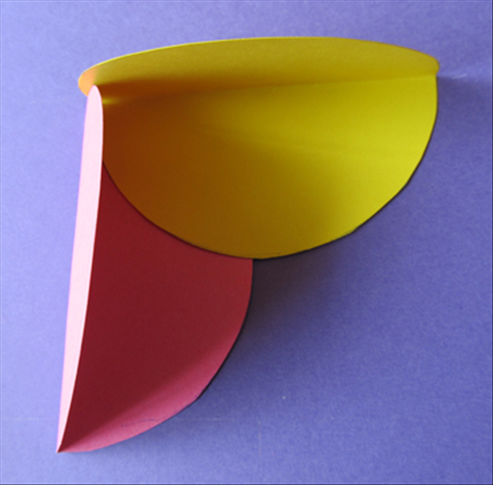 Place one color circle so that the straight folded edge makes a corner with a different color.